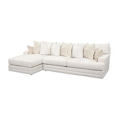 a white sectional couch with pillows on it's back and side facing each other