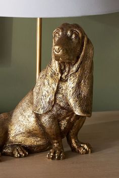 a golden dog figurine sitting under a lamp