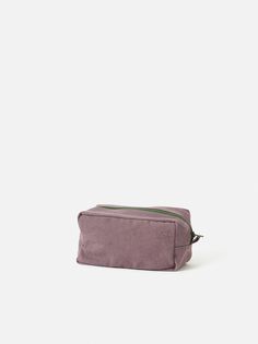 a small purple bag sitting on top of a white surface