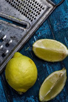 two limes and a grater on a blue table