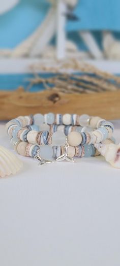 TitiTataStore.etsy.com Always FREE SHIPPING and a FREE GIFT! I Will Ship Within 24 Hours! Description: A Beautiful Set of 2 Coastal Style Beachy Bracelets.  Materials: 8mm Frosted White Sea Glass Beads, 8mm Matte Ivory Fossil Jasper Beads, 8mm Mystic Aura Quartz Beads, 8mm Rondelle Blue Quartz Beads, Light Blue Jade Rondelle Beads, 8mm Natural Wood Beads, 8mm Natural White Matte Magnesite Beads, Seashells Heishi Beads, 8mm Matte Fossil Coral Riverstone, and 8mm Brushed Silver flat disc beads spa Bracelets Seashell, Bracelets Beachy, Coastal Bracelet, Nautical Ideas, Beachy Bracelets, Lover Birthday, Seashell Bracelet, Coastal Jewelry, Beachy Jewelry