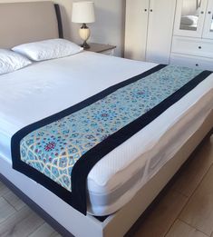 a bed with a blue and white bedspread sitting on it's side