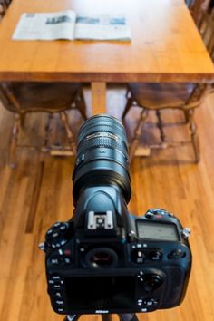 a camera sitting on top of a tripod in front of a dining room table