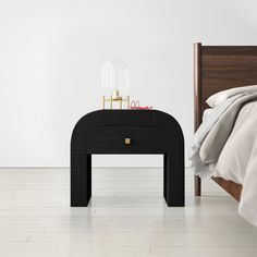 a bed with a wooden headboard and night stand next to it on a white floor