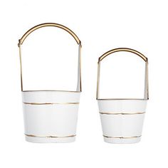 two white buckets with gold handles on each side and one holding a handle in the middle