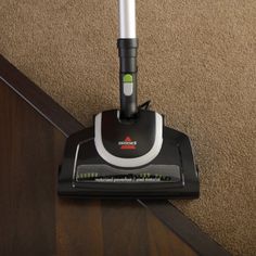 a close up of a vacuum cleaner on the floor with carpeting in the background