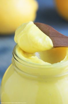 a spoon full of lemon curd sitting on top of a jar