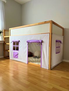 a doll house made out of cardboard with purple trim