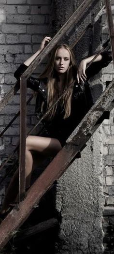 a beautiful young woman posing on some stairs