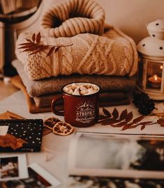 a coffee cup with hot chocolate in it sitting on top of a table next to other items