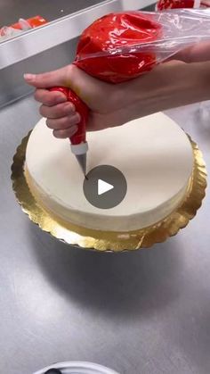 a person is cutting into a cake with a knife and plastic wrap on it's edge