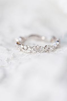 a diamond ring sitting on top of a white surface