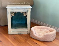 a dog bed sitting on the floor next to a couch