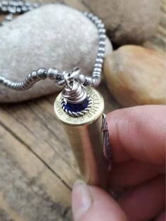 Stunning rifle casing embellished with a highly detailed filigree stamping. Blue sapphire beads are used in place of bullet and at the top, wire wrapped and secured. Hung from a generous 34 inch stainless steel ball chain. We use rifle calibers like 308, 30-30, 7mm and 303 British for this necklace which have an opening to fit the faceted beads. You will receive one of those! Sapphire is the birthstone of September, symbolic for beauty, prosperity and intuition. 303 British, Bullet Designs, Sapphire Beads, Bullet Necklace, Bullet Jewelry, Ball Chain, Faceted Bead, Wire Wrapped, Blue Sapphire