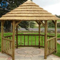 a wooden gazebo sitting on top of a lush green field