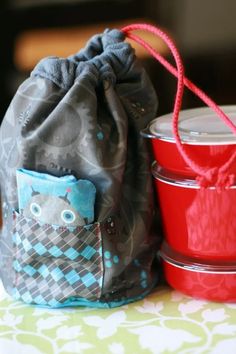 two small containers and a drawsack bag sitting on a table