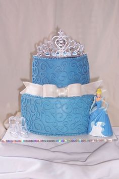 there is a blue cake with princess decorations on it