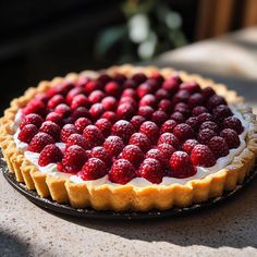 a pie topped with raspberries on top of a table