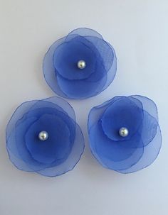 three blue flowers with pearls in the center