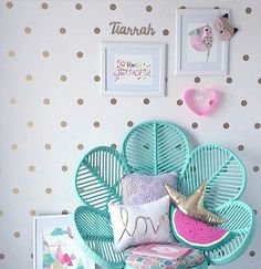 a chair with some pillows on top of it in front of a polka dot wall