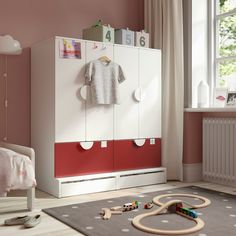 a child's bedroom with pink walls and white furniture