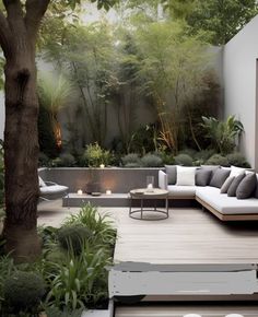 an outdoor living area with couches, tables and trees