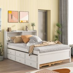 a white bed sitting in a bedroom next to a wooden floor and yellow painted walls