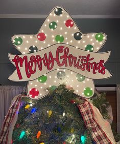 a merry christmas sign on top of a tree