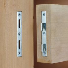 a wooden door with two metal latches on it