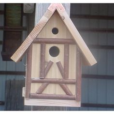 a bird house hanging from a wooden pole