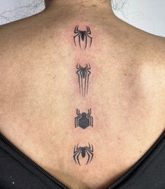 the back of a woman's neck with four spider - man tattoos on it