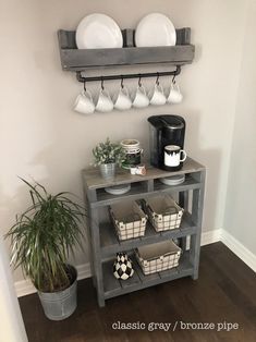 there is a shelf with plates and cups on it next to a potted plant