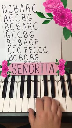 someone is playing the piano with pink flowers on it's cover and sheet music