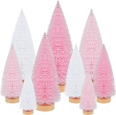 pink and white christmas trees are lined up against each other on wooden bases in front of a white background