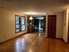 an empty living room with wood floors and hard wood flooring in the middle of it