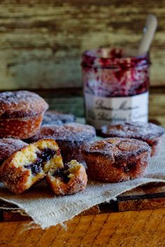 powdered donuts on a napkin with jam in the background