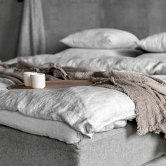 an unmade bed with pillows and blankets on it