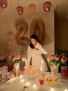 a woman standing in front of a birthday cake