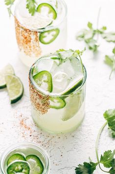 three glasses filled with cucumber and limeade on top of a cutting board