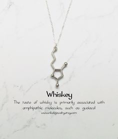 a necklace with the word whiskey on it and an image of a chemical symbol in silver