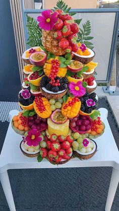 a very tall cake with lots of fruit on it