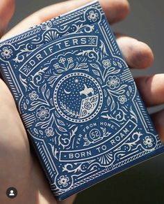 a person holding a blue playing card in their hand