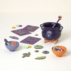 an assortment of toys and magnets on a white surface, including a purple pot