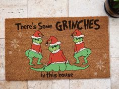 there's some grinches in this house door mat on the floor next to a potted plant