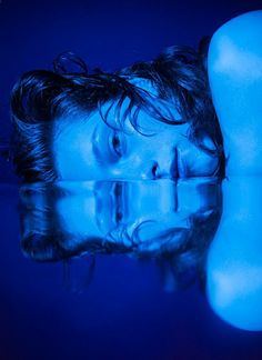 a woman is laying down in the water with her head resting on her chest and eyes closed