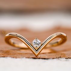 a diamond ring sitting on top of a piece of wood