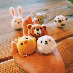 small stuffed animals sitting on the palm of someone's hand in front of them