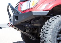 the front end of a red four - door truck with an off road bumper guard