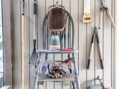 a chair with gardening tools hanging on the wall