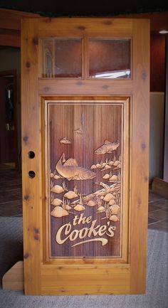 a wooden sign that says the cookie's in front of a door with fish on it